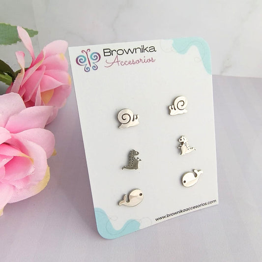 Set de aretes plateados en acero quirúrgico 316L para mujer – caracol, dinosaurio y ballena